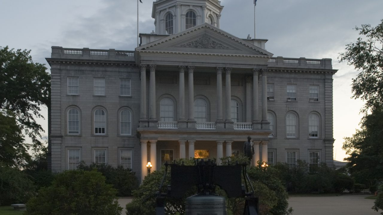 A view of the New Hampshire State House in Concord. In the foreground is a replica of the Liberty Bell. Designed by Stuart James Park and constructed from 1816 to 1819, the Classical Revival building is the oldest state capitol in which the legislature meets in its original chambers.