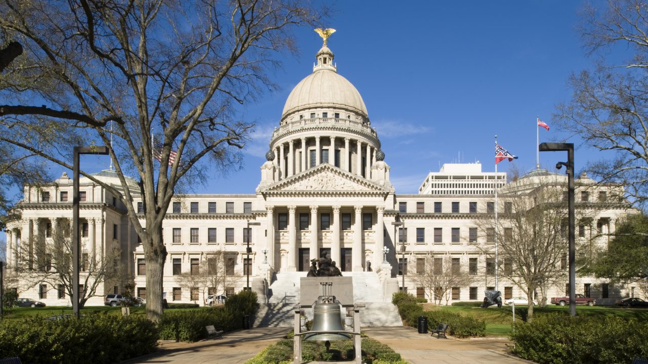 A view of the Mississippi State Capitol in Jackson. In the foreground stands a replica of the Liberty Bell. Designed by Theodore C. Link and completed in 1903, the Beaux-Arts structure is listed on the National Register of Historic Places.