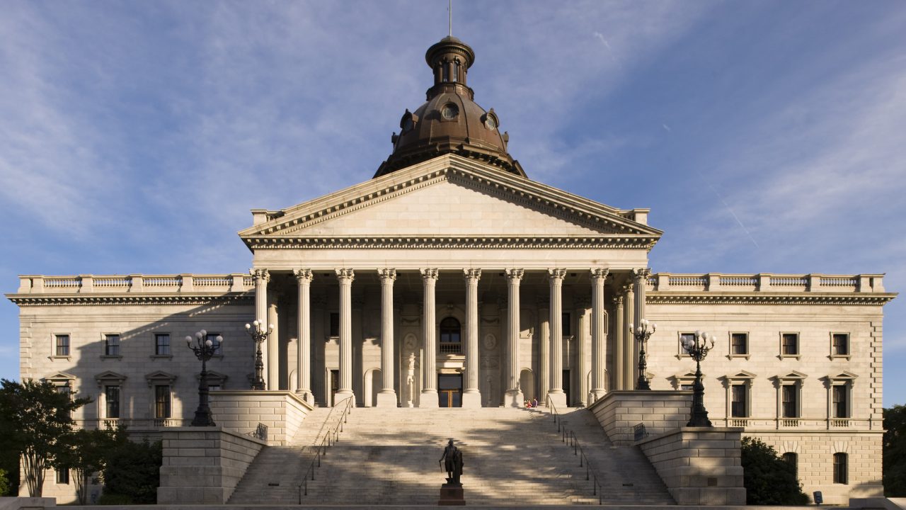A view of the South Carolina State House in Columbia. A statue of George Washington stands on the steps of the State House. Originally designed by John R. Niernsee, constuction began in 1851, with the main structure of the building being completed in 1875. The Classical Revival structure is a National Historic Landmark.