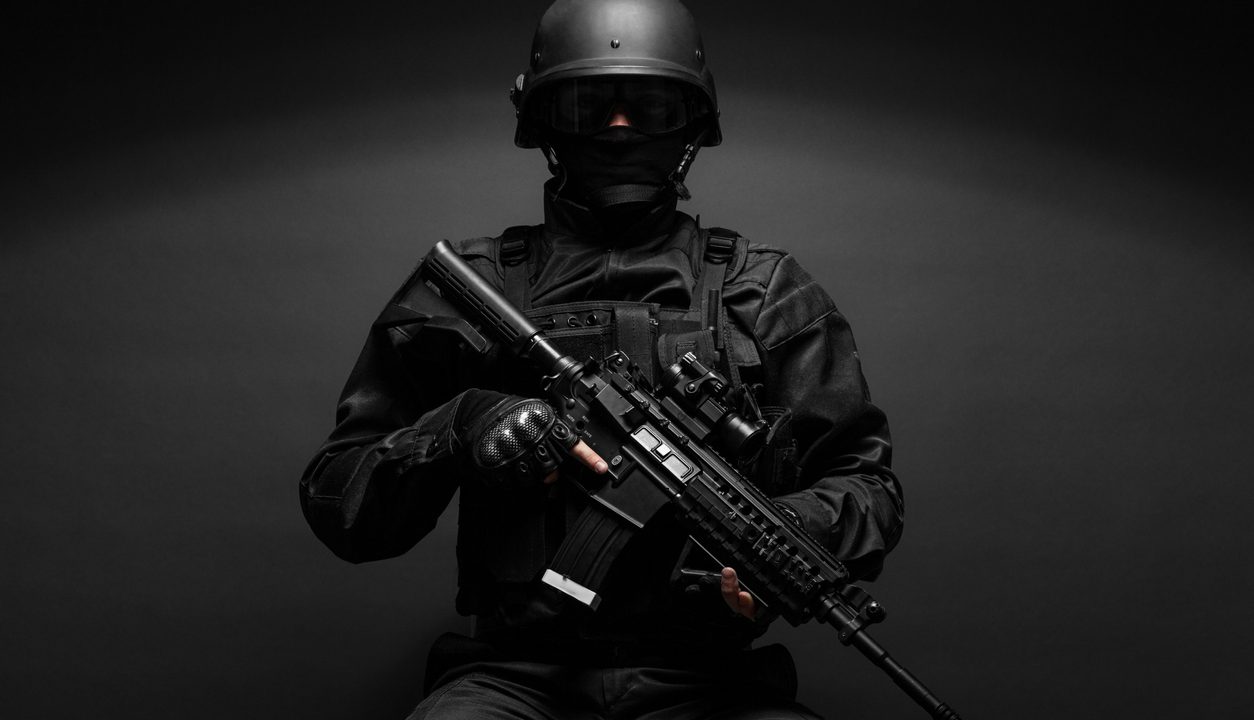 Spec ops police officer SWAT in black uniform studio