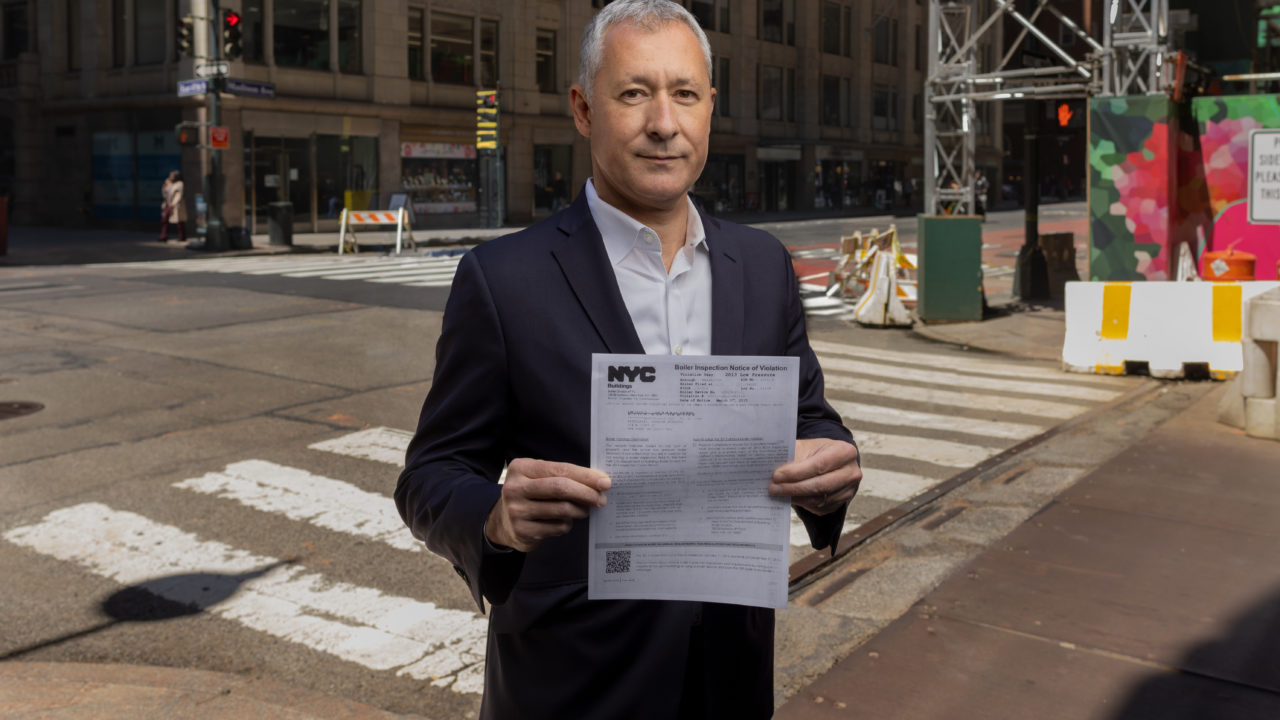 Serafim Katergaris holds the unreviewable fine he was issued by the Department of Buildings for a violation he didn't commit.