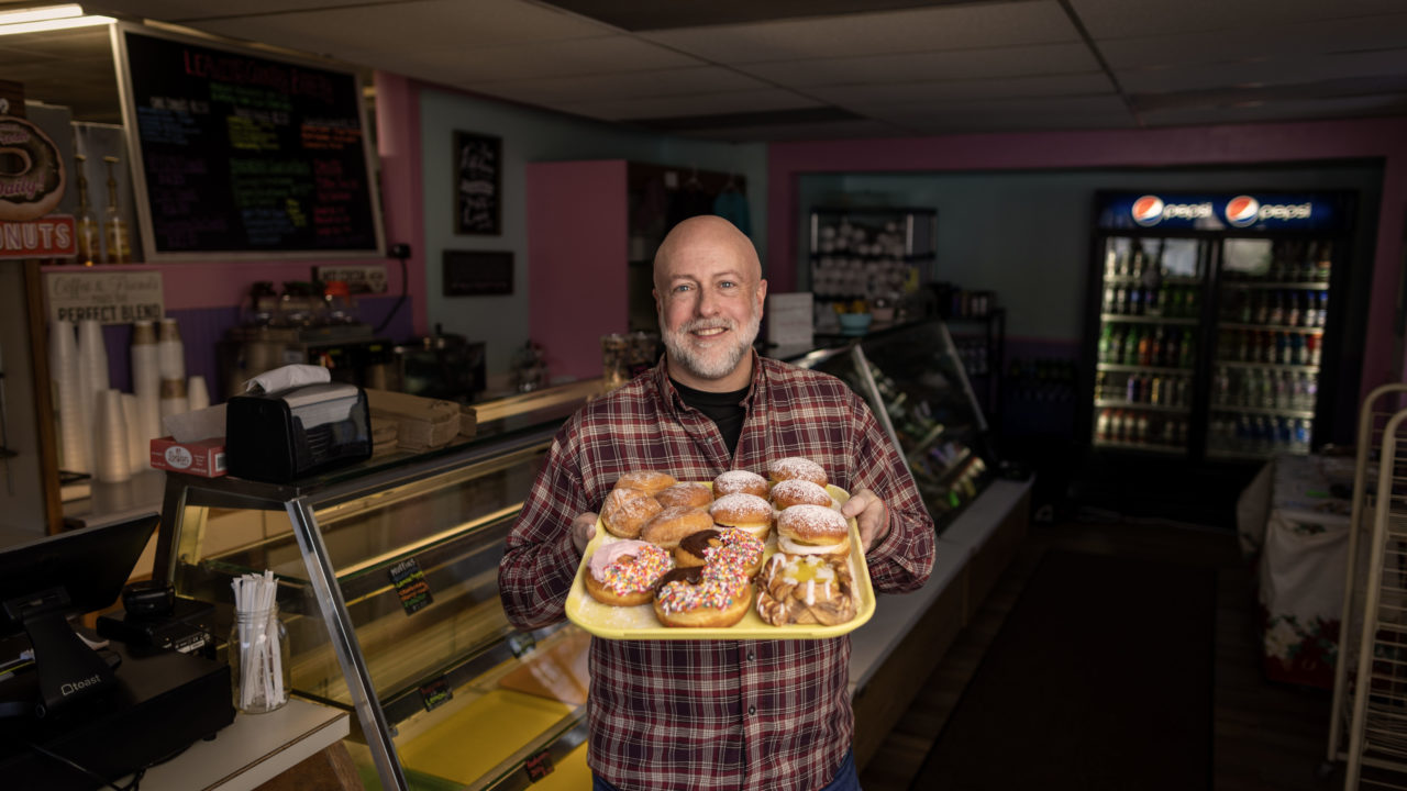 Leavitt's Country Bakery Owner Sean Young holds some fresh made donuts inside his bakery.