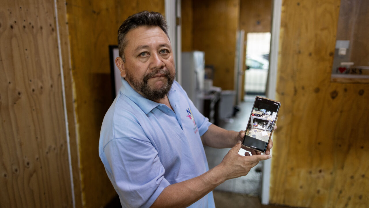 Carlos Pena shows photos of the damage an LAPD SWAT team did to his printing shop in August 2022. The city refused to compensate him for the damage.
