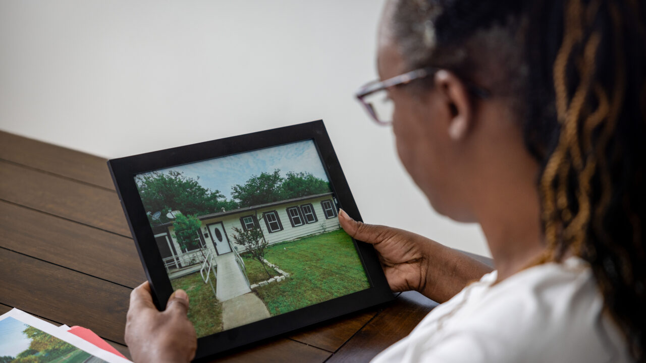 Karen Jimerson looks at a photo of her former home in Lancaster, Texas, which police raided when serving a warrant for a different home down the street. She and her partner are asking the United States Supreme Court to overturn a lower court ruling granting qualified immunity to the officer who ordered the SWAT raid at the wrong home.