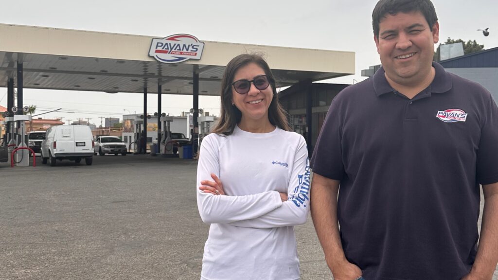 woman and man standing outside gas station