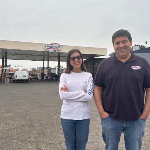woman and man standing outside gas station
