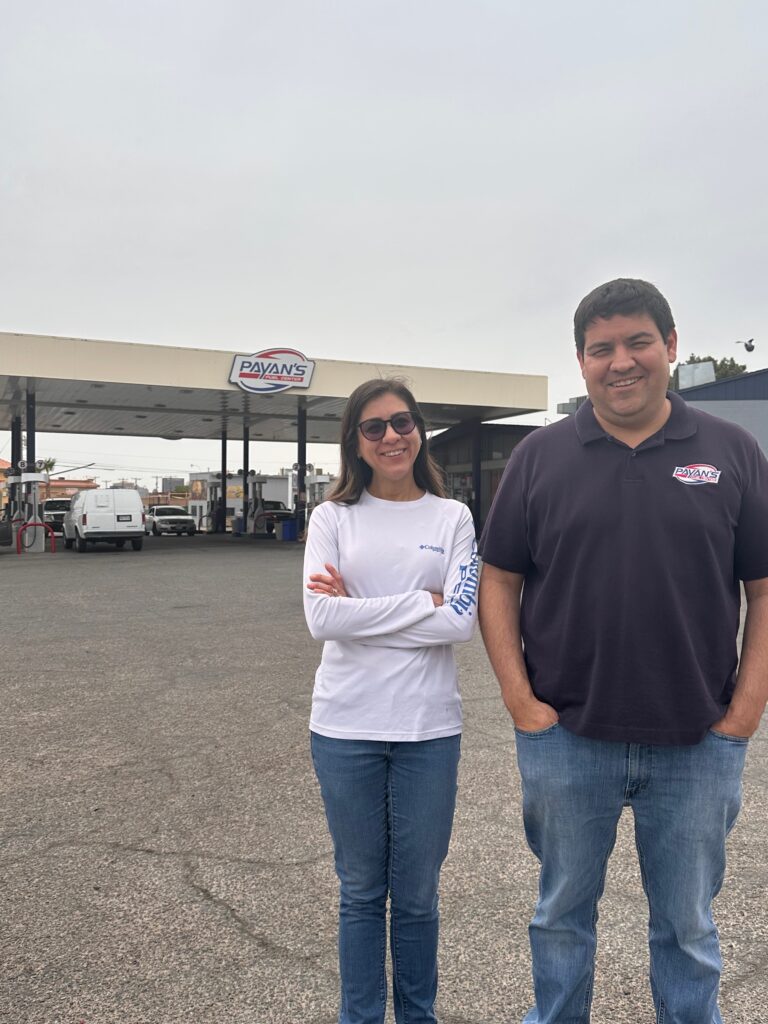 woman and man standing outside gas station