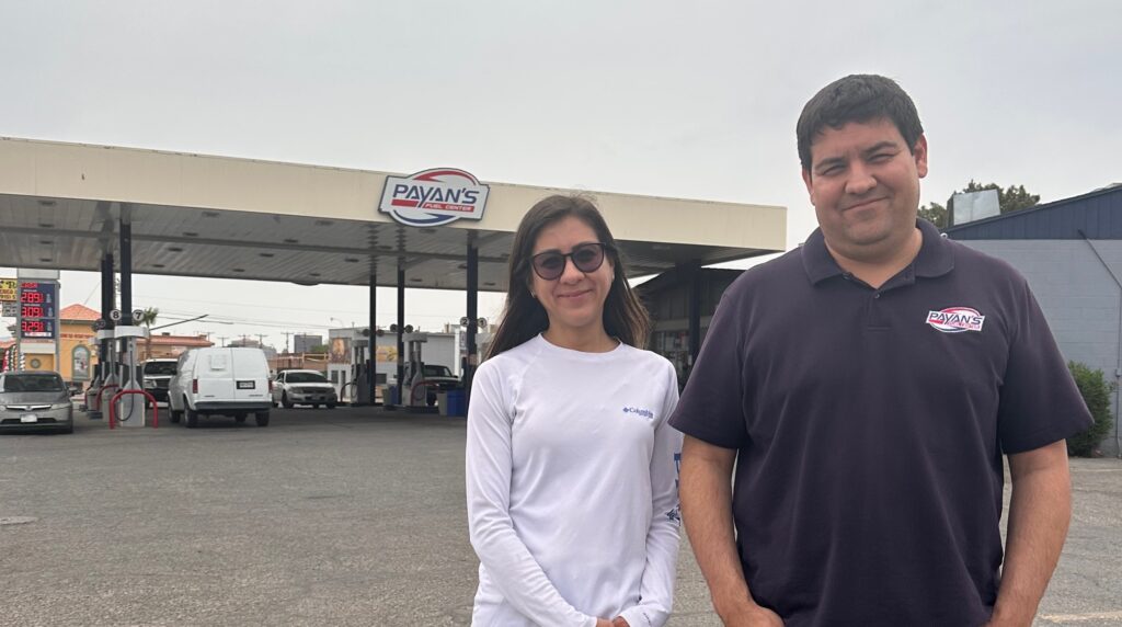 woman and man standing outside gas station