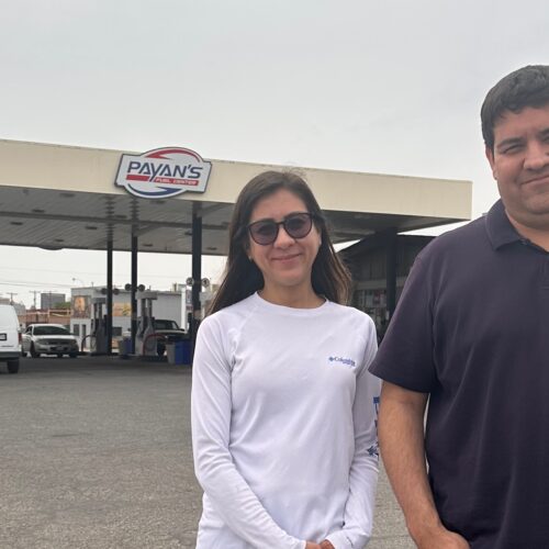 woman and man standing outside gas station