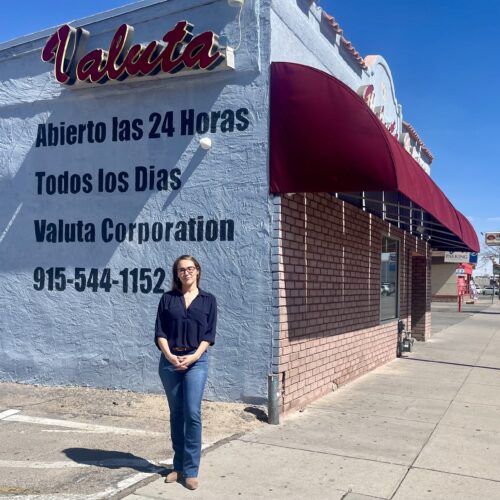 woman stands in front of business