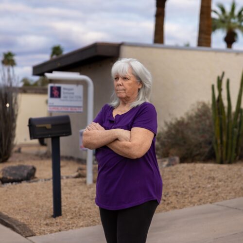 woman standing in front of home