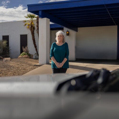 woman standing in front of home