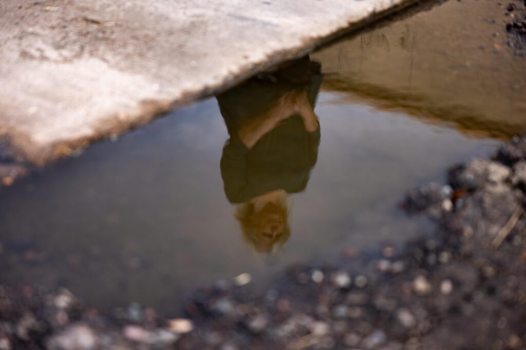 woman's relfection in puddle