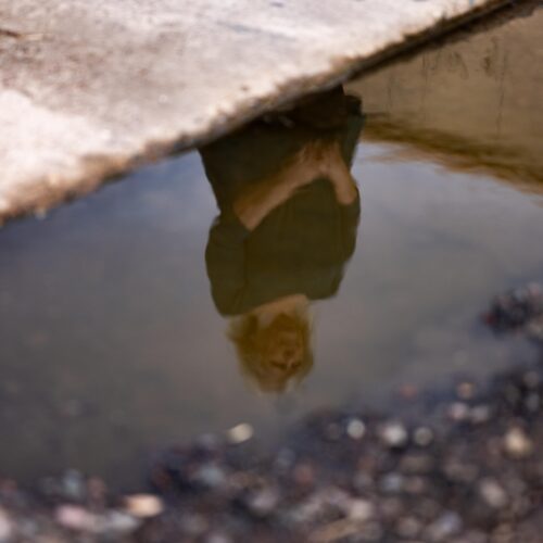 woman's relfection in puddle
