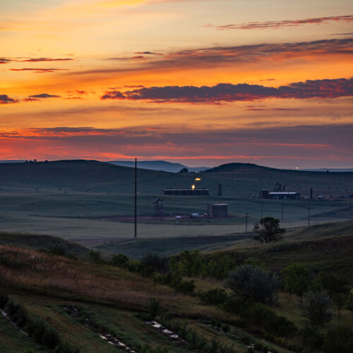 ranchland with fossil fuel infrastructure in the morning light
