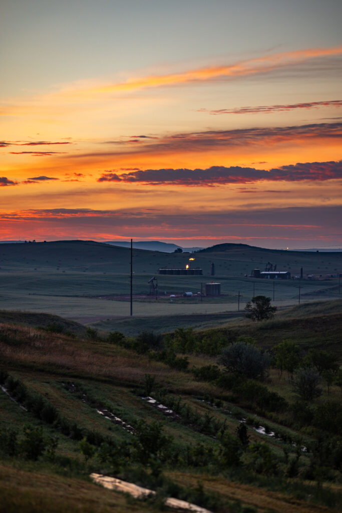 ranchland with fossil fuel infrastructure in the morning light