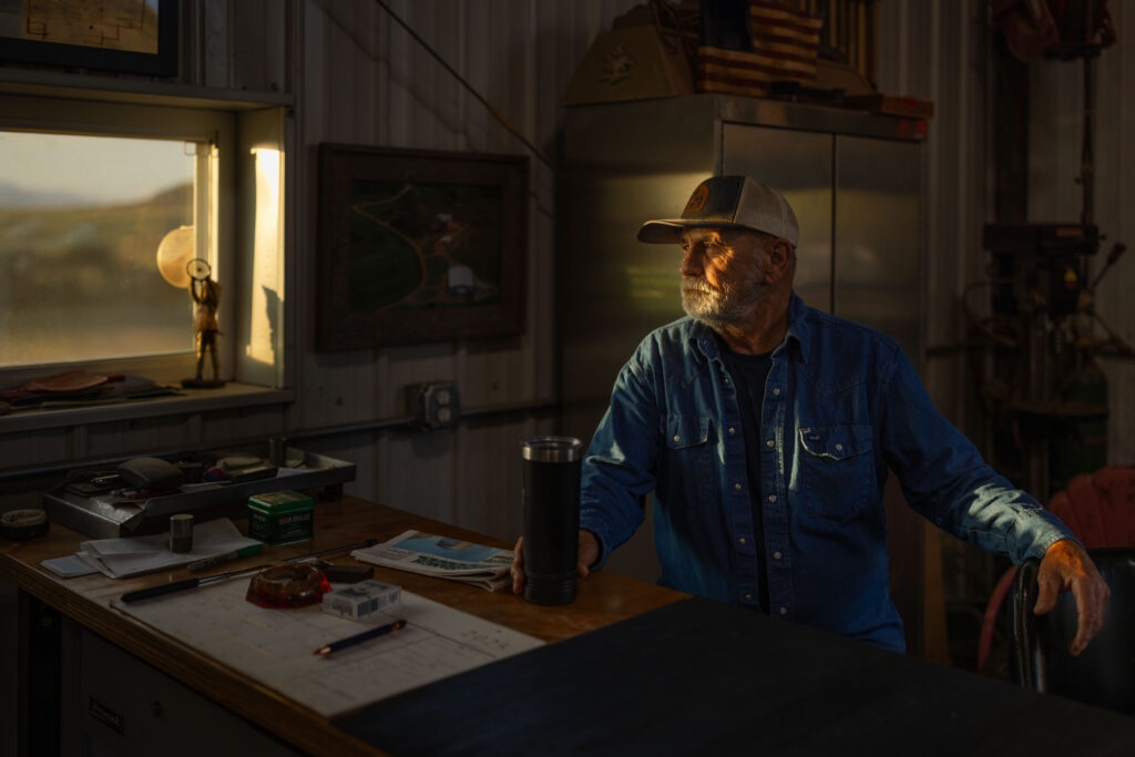 rancher sitting in barn in the morning light