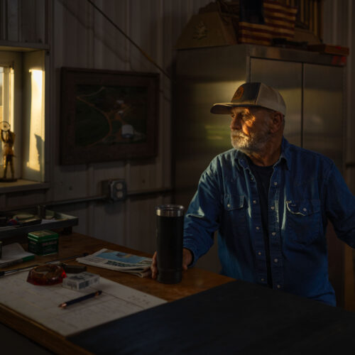 rancher sitting in barn in the morning light