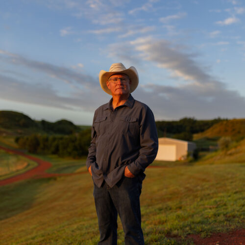 rancher wearing cowboy hat in morning light