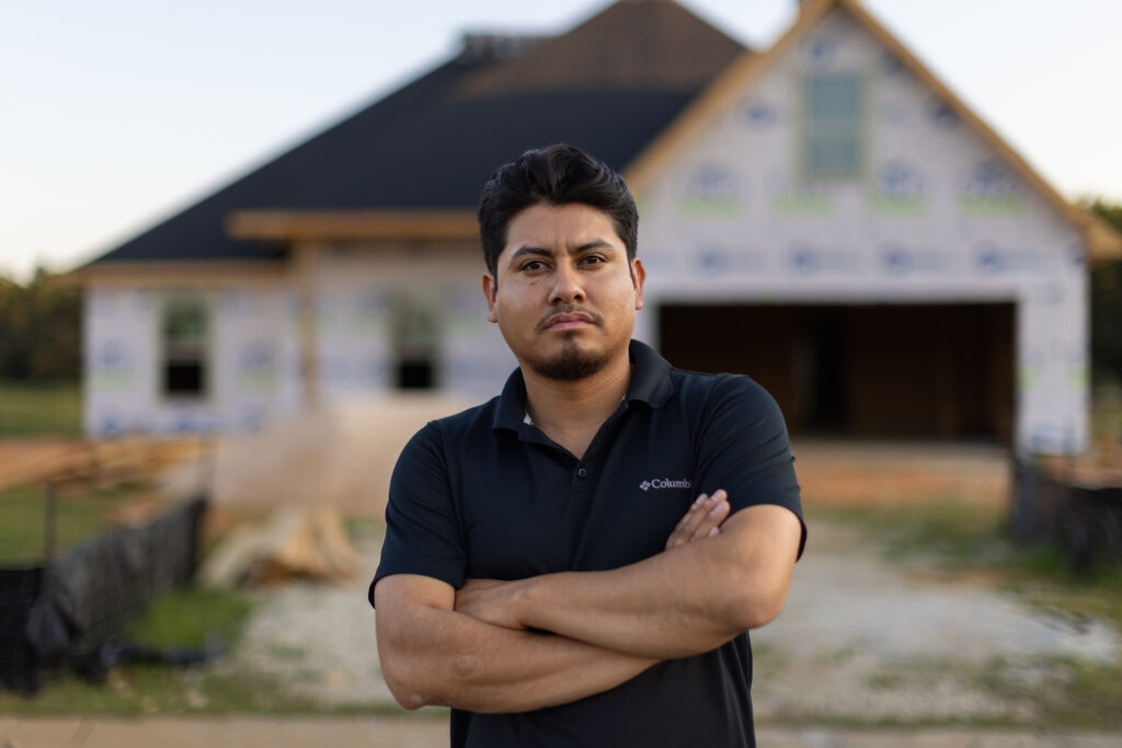 construction worker in front of partially built home