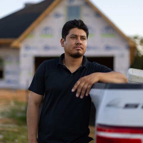construction worker in front of partially built home