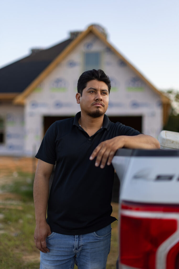 construction worker in front of partially built home