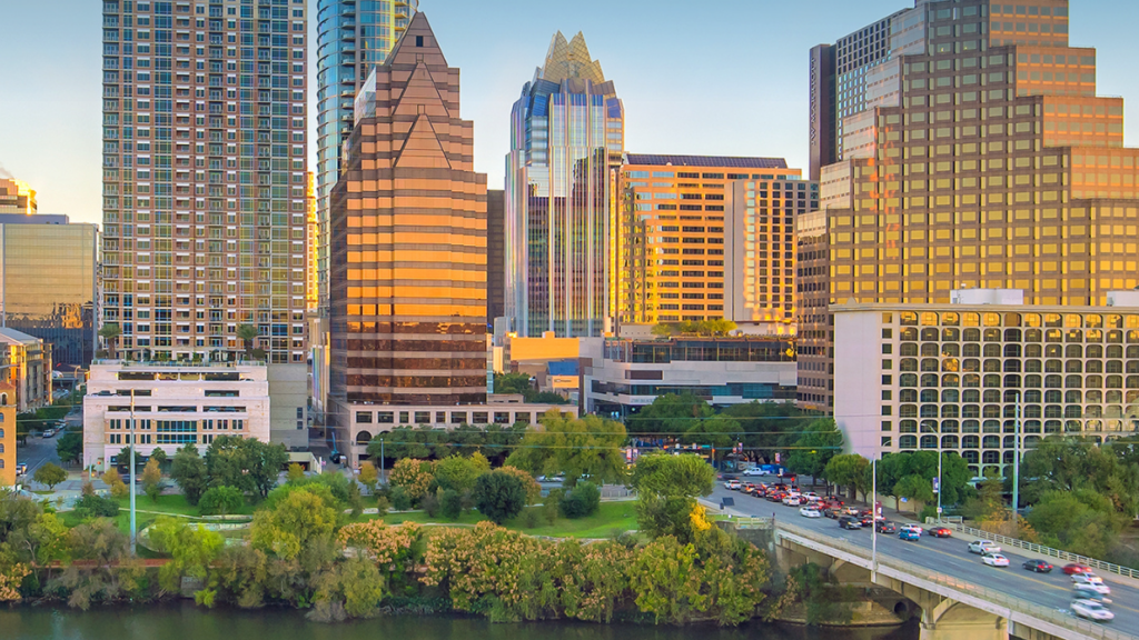 Austin, Texas skyline with riverfront, bridge, and downtown skyscrapers at sunset