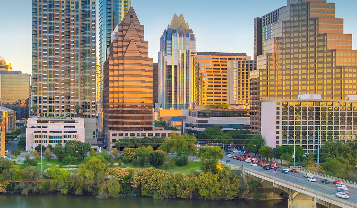 Austin, Texas skyline with riverfront, bridge, and downtown skyscrapers at sunset