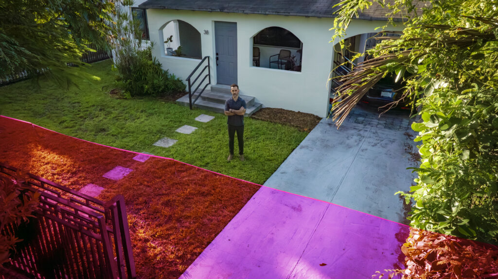 A man standing outside his house with a graphic showing the property the city wants to take.