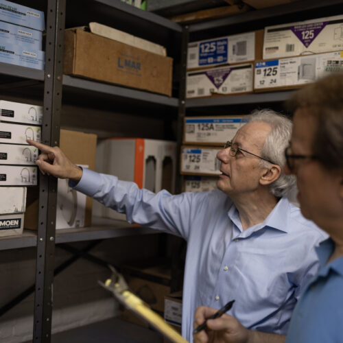 Pashko and Tony Lulgjuraj going through inventory at their apartment building.