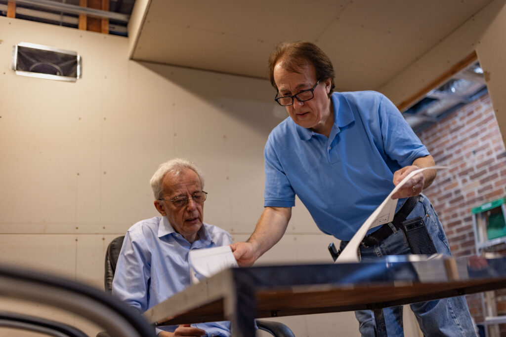 Pashko and Tony Lulgjuraj going over the plans of their apartment building.