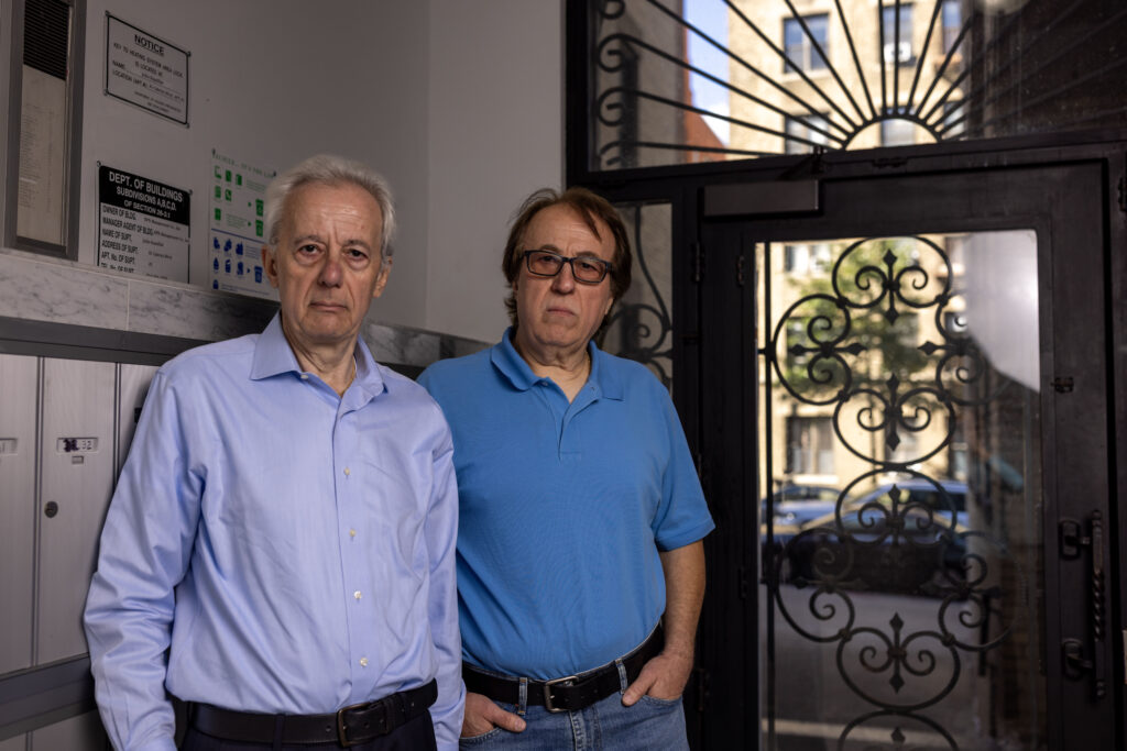 Pashko and Tony Lulgjuraj standing in the entrance of their apartment building.