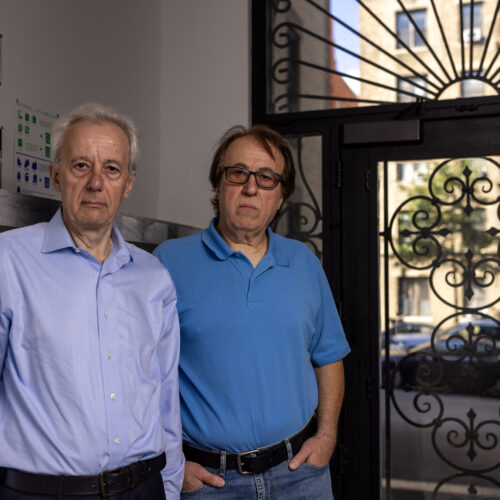 Pashko and Tony Lulgjuraj standing in the entrance of their apartment building.