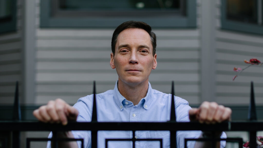 Leo Feler stands inside his fence at his home in Chicago, which was warrantlessly raided by Customs and Border Protection officers in October 2025.