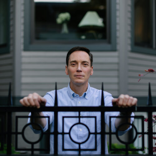 Leo Feler stands inside his fence at his home in Chicago, which was warrantlessly raided by Customs and Border Protection officers in October 2025.