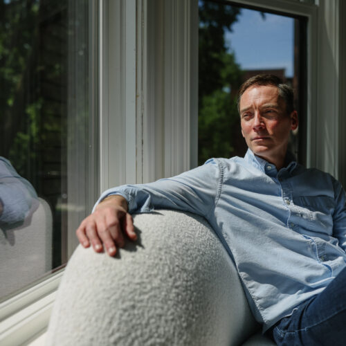 Leo Feler sits inside his home in Chicago, which was warrantlessly raided by Customs and Border Protection officers in October 2025.