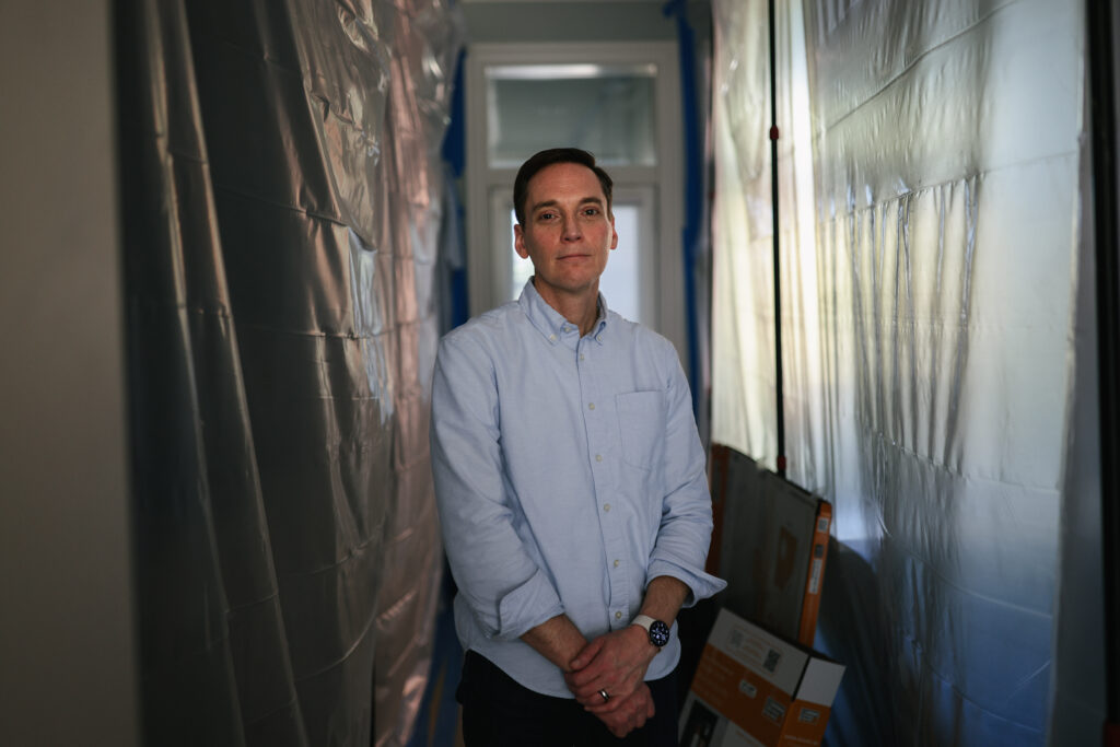 Leo Feler stands in a portion of his Chicago home that is still under construction. The home was warrantlessly raided by Customs and Border Protection officers in October 2025.