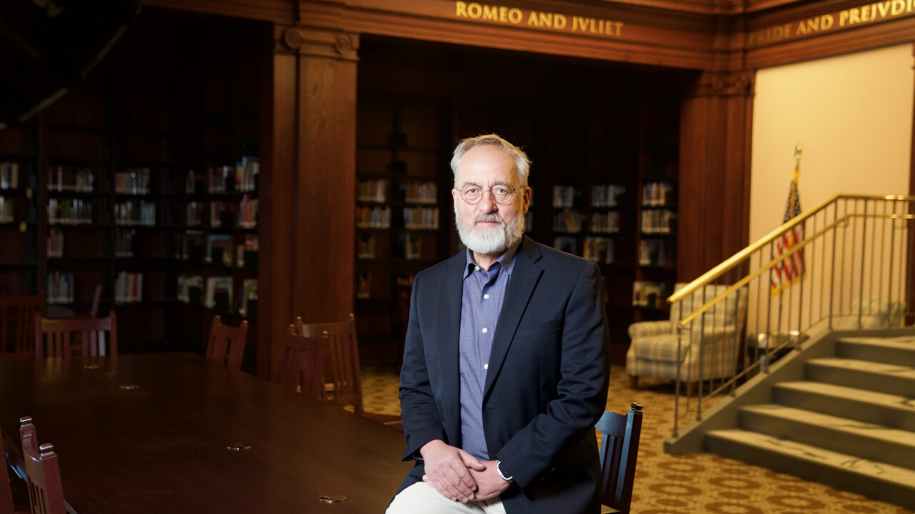 Capstone Chairman Ronald Robson sitting on a table in North Dakota library