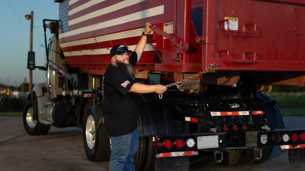 Joshua Roman, founder of American AF Dumpsters, preparing to offload one of his roll-off dumpsters.