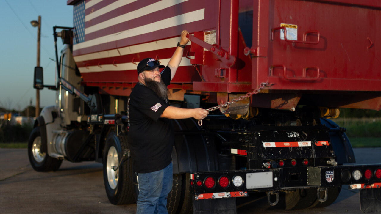 Joshua Roman, founder of American AF Dumpsters, preparing to offload one of his roll-off dumpsters.