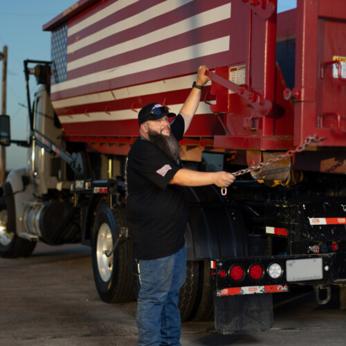 Joshua Roman, founder of American AF Dumpsters, preparing to offload one of his roll-off dumpsters.