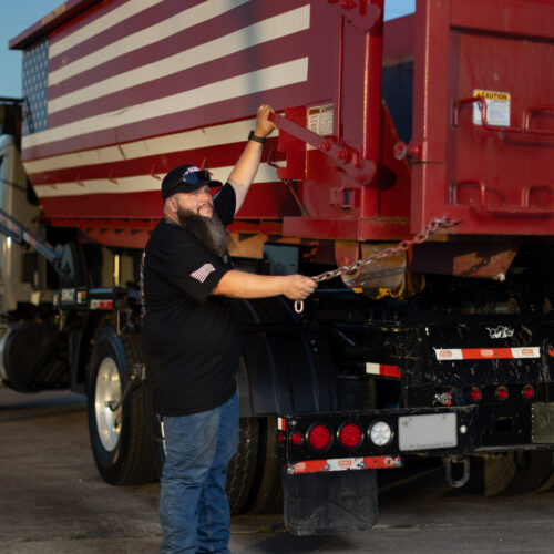 Joshua Roman, founder of American AF Dumpsters, preparing to offload one of his roll-off dumpsters.