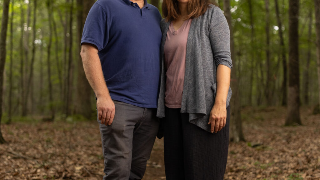Charles and Eli Copley stand close together on a wooded trail on their Roxbury, Connecticut property