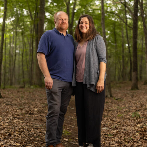 Charles and Eli Copley stand close together on a wooded trail on their Roxbury, Connecticut property