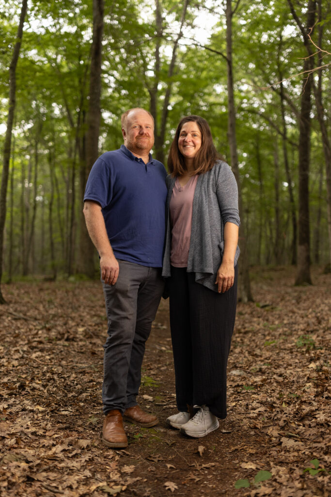 Charles and Eli Copley stand close together on a wooded trail on their Roxbury, Connecticut property