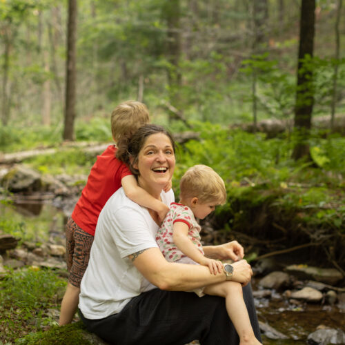 Eli Copley laughs with her children by a wooded stream on her Roxbury, Connecticut property