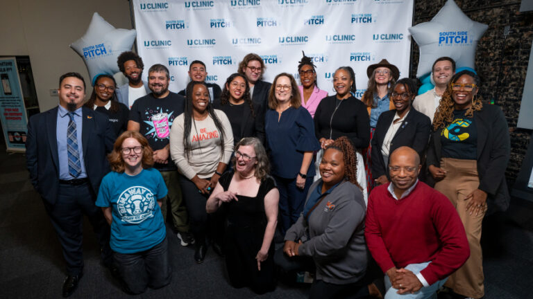 Group posing together in front of a South Side Pitch backdrop at an IJ Clinic event