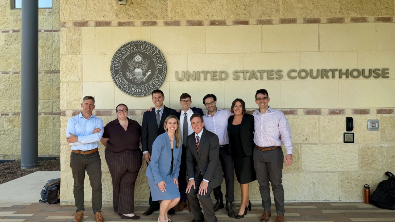 Alek Schott and IJ trial team posing outside United States Courthouse, Western District of Texas