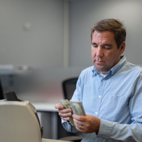 Steven Bailey counts cash inside Global Coin Logistics' office in Louisville, Kentucky.