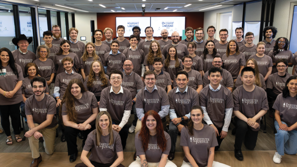 Large group in matching Institute for Justice T-shirts poses at the 2026 Law Student Conference